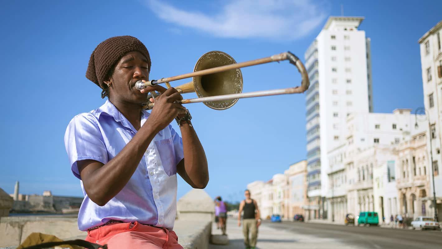 Cuban musician playing trombone in havana malecon